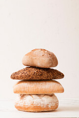 Fototapeta na wymiar Bread, pastries on a light background. Bread with sesame seeds and seeds, bread texture. Delicious flavored bun. Lots of airy fresh bread.