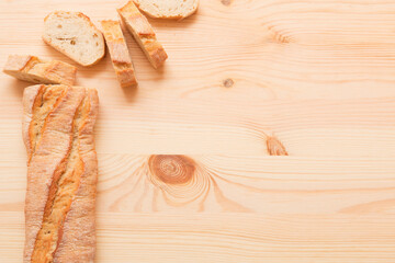 Sliced ​​baguette. Pieces of bread. Pastries on a light wooden background.