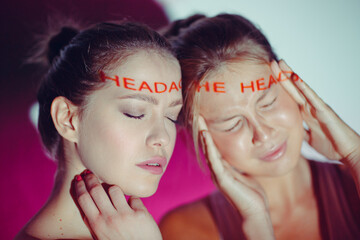 Young adult woman holds hands on head ad having suffering facial expressions with word Headache on...