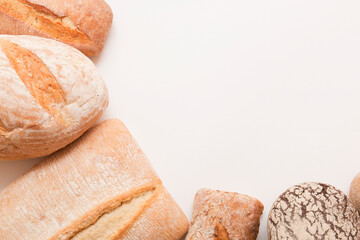 Lots of different fresh breads on a light background. Fragrant airy baked goods. Sliced ​​bread.