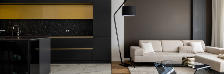 Modern black kitchen open to elegant living room, panorama
