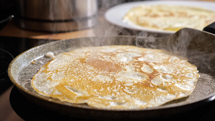 Close up of frying pancake in a pan.