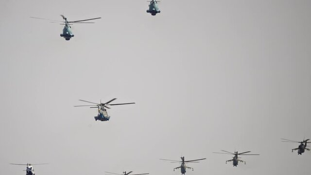A group of army helicopters flies in the sky. Militarized army air force.