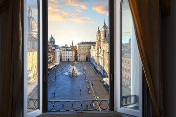 View from an open window overlooking the Piazza Navona at sunrise showing Bernini's Fountain of...