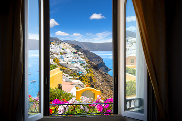 View from a resort window overlooking the whitewashed town of Oia, Santorini, Greece and the Aegean Sea.
