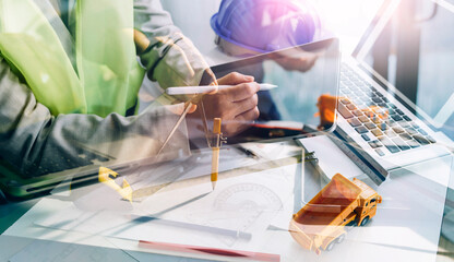 Construction engineer working at blueprint to build large commercial buildings in office. Engineering tools and construction concept.