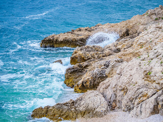 Fototapeta na wymiar Waves on the beach with bays and rocks in Croatia