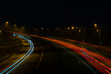 Fototapeta na wymiar Night road lights. Lights of moving cars at night. long exposure red, blue, orange, multicolored