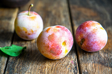 Home harvest fresh plums on a wooden table.
