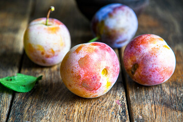 Home harvest fresh plums on a wooden table.