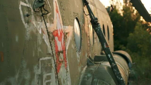 An old and damaged helicopter from the Soviet Union MI-8. Cinematic video in the rays of the setting sun.