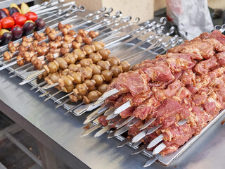 There are a lot of meat and vegetable skewers on the counter. Street food concept.