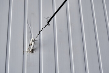 White colored hook and tied with metal wire on in with white background.