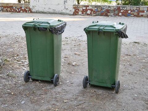 Two large green garbage containers on the street. Ecology and cleanliness in the city.
