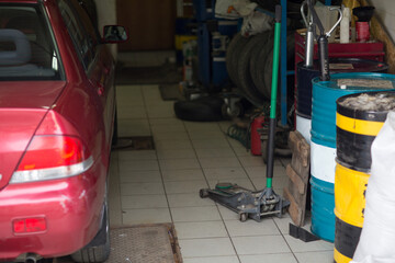 Hydraulic car jack to lift car in auto repair.