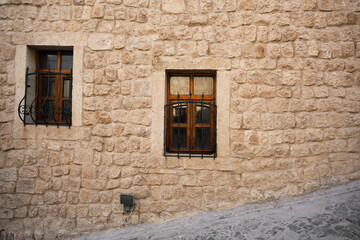 Angled way made of and covered by cobblestone and wooden window on facade of house in Cappadocia Turkey