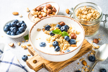 Yogurt with granola and fresh berries at white table. Healthy food, snack or breakfast.
