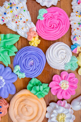 Colorful sweet meringues on a wooden background