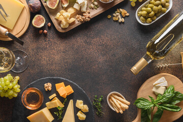 Fototapeta na wymiar Cheese platter with grapes, nuts, figs on a brown background. Top view. Copy space. Appetizer for festive party.
