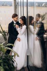 Stylish european wedding couple hugging and looking at each other.