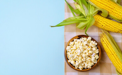 Fresh uncooked corncob, popcorn. Healthy summer food concept. Blue Background. Copyspace