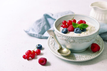 Oatmeal porridge with fresh berries and maple syrup for a breakfast.