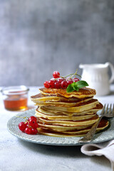 Delicious hot pancakes with fresh berries and maple syrup for a breakfast.