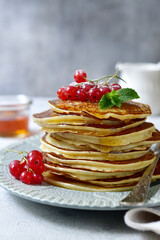 Delicious hot pancakes with fresh berries and maple syrup for a breakfast.