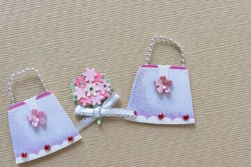 two fancy paper  hand bags with a bouquet of paper flowers
