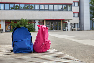 The beginning of the school year, lessons. Two backpacks stand on a bench against the backdrop of...