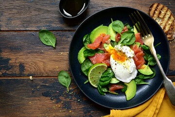 Healthy breakfast : green vegetable salad with salted salmon and poached egg. Top view with copy space.