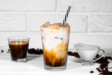 Milk Being Poured Into Iced Coffee on white background, Summer refreshment drink with a straw, A lot of Coffe bean