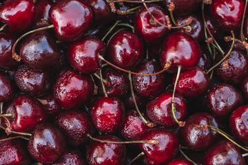 Background image of lying red ripe sweet cherries. Top view, flat lay. Copy space