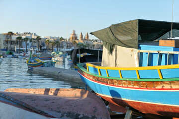 Fototapeta na wymiar Colorful fishing luzzu boats in Malta harbor in Marsaxlokk