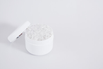 Fototapeta na wymiar Blank white jar with bath salt on gray background, cosmetic mock up