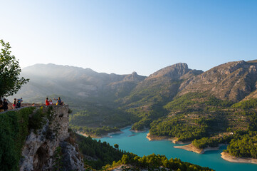 Stunning view of a lake in between the mountains and on the left side of the picture  there is a family taking a selfie.