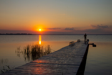 Fishing with a spinning rod at dawn. Rising Sun.