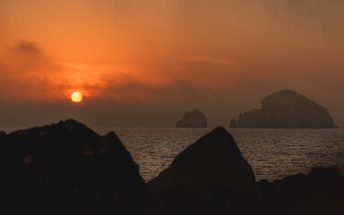 Fototapeta na wymiar Tropical sunset islands in the background rocks in foreground