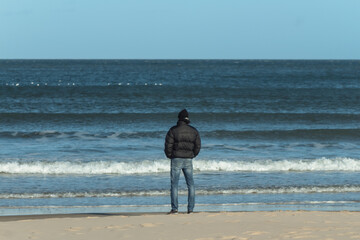 Fototapeta na wymiar Mid caucasian adult standing at shoreline contemplating the horizon