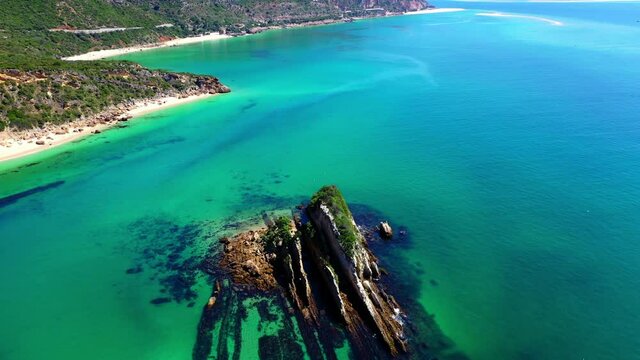 Aerial Panning Scenic View Of Birds Flying Over Island In Sea On Sunny Day - Setubal, Portugal