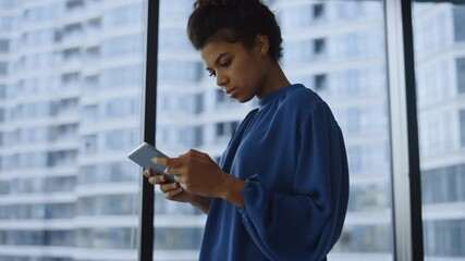 Businesswoman standing at window with tablet Woman typing on digital tablet