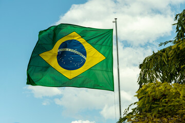 Flag of Brazil fluttering in the wind. In the center of the flag with the words "order and progress" in Portuguese