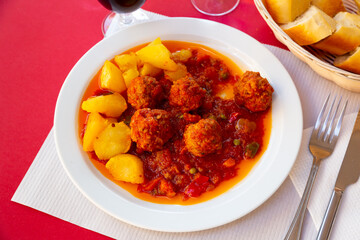 Appetizing smoky spanish Albondigas, meatballs cooked in tomato sauce with potatoes