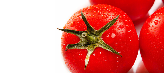 Ripe juicy red tomatoes in droplets of water on a white background