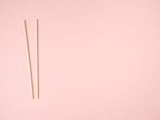 bamboo chopsticks on pink pastel background.