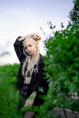 Young beautiful blonde girl in a black denim jacket, nature, fashion portrait 