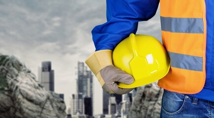 Worker man with helmet in hands on background