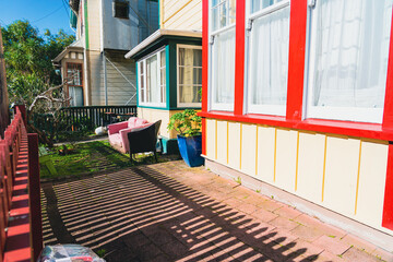 Small urban front yard with old couch from street with picket fence and shadow