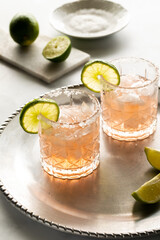 Two margarita mocktails garnished with lime and salted rims, ready for drinking.