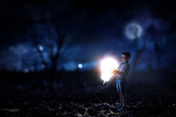 Fototapeta na wymiar Boy with a glowing light bulb
